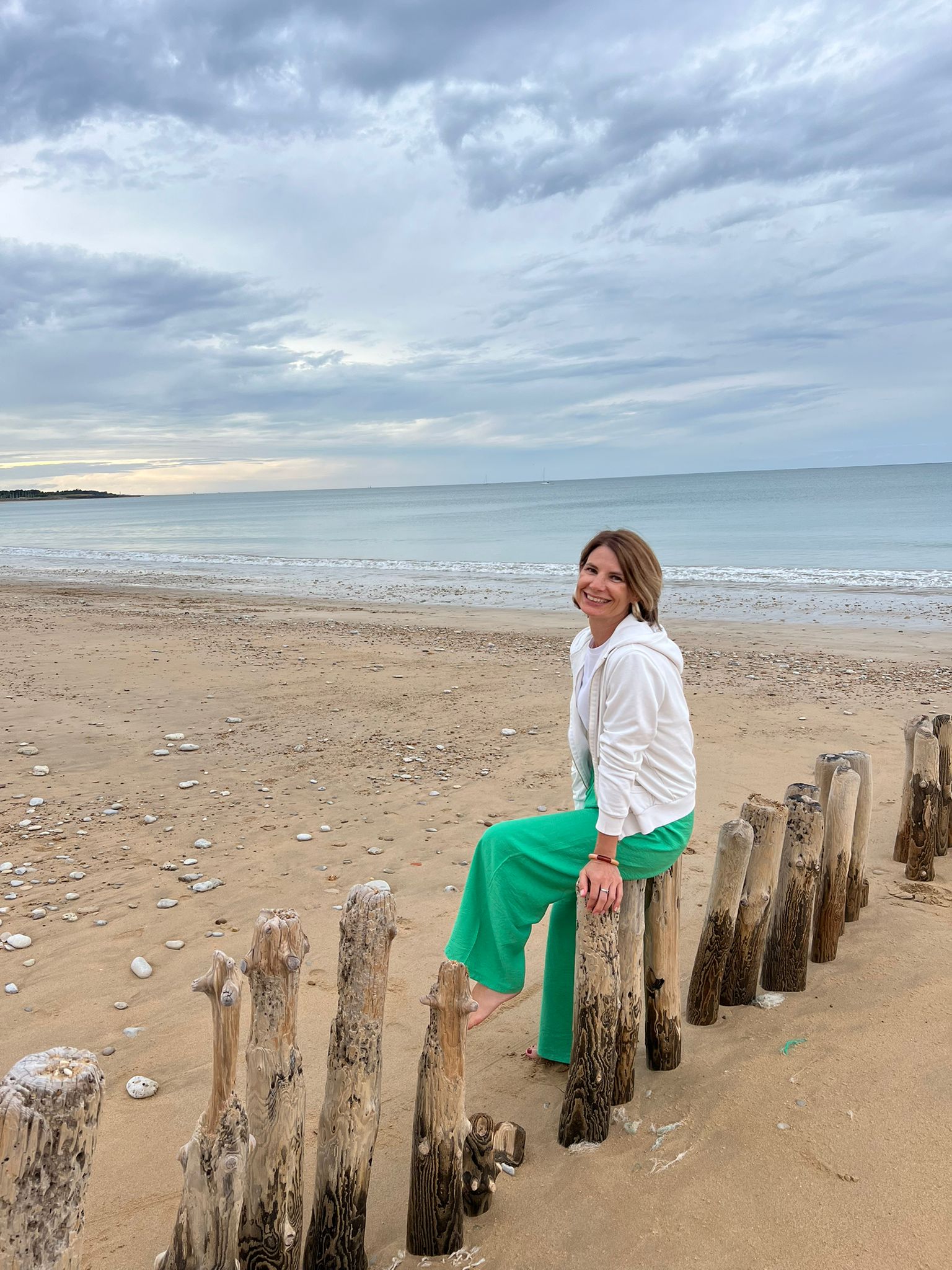 Claire Baeteman assise sur la plage, symbole de douceur et d’apaisement intérieur à Tours